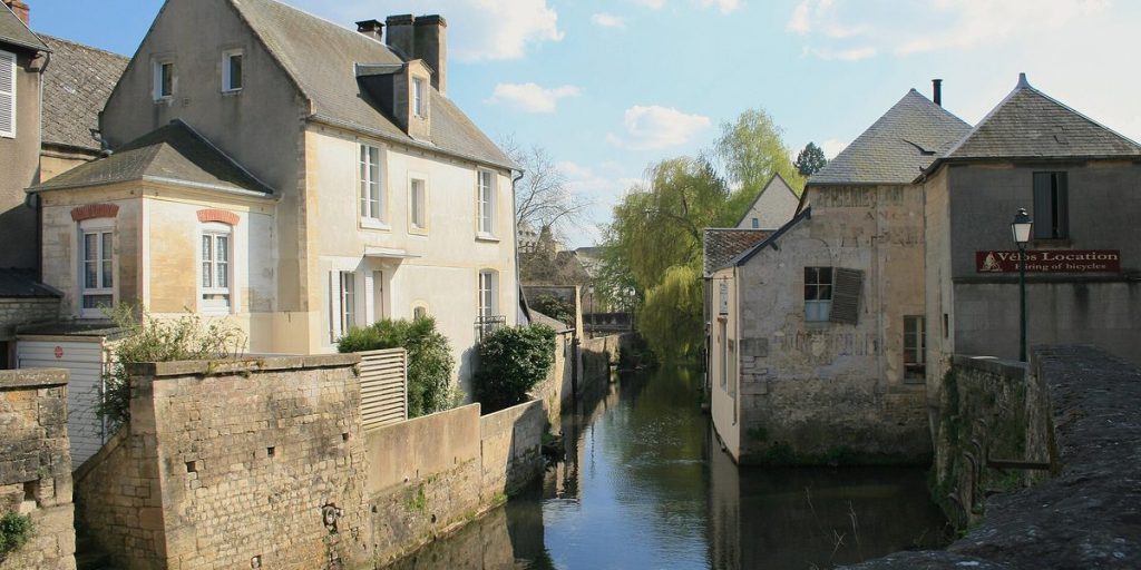The river Aure and old stone houses seen from the rue Saint-Jean bridge in Bayeux